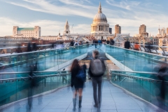 People walking on Millennium Bridge towards St. Paul's Cathedral in London